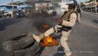 Haitian Police kicking a burning tire during a street protest